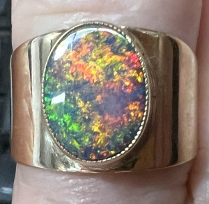 Lot 320 - 9ct ygold black Opal ring - wide band, raised rubbed in setting - TW a