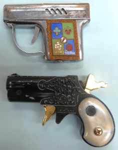 Lot 286 - 2 x novelty Pistol Cigarette lighters, incl Modern Angel Mascot and Fl