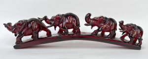 Lot 256 - Vintage red reconstituted Amber carving of 4 elephants walking over in